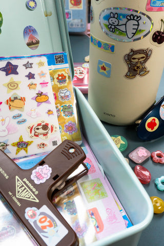 Pink sticker icons on desk items, including hearts, roses, and character faces