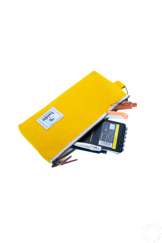 Yellow gusseted pen case packed with stationery, zipper closed