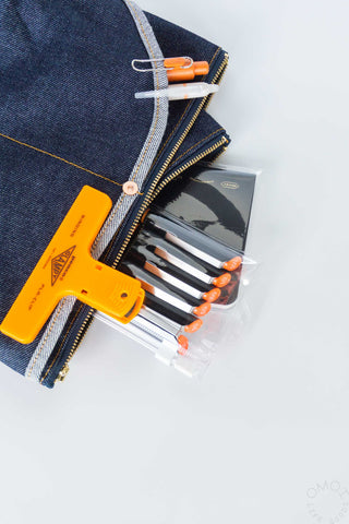 Denim double-pocket pouch with zip opening, orange accents, and interior organizers