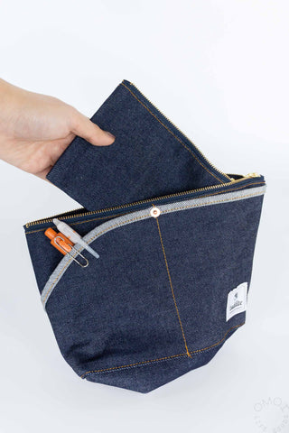 Denim double-pocket boat pouch, hand-held open view with zipper and logo patch