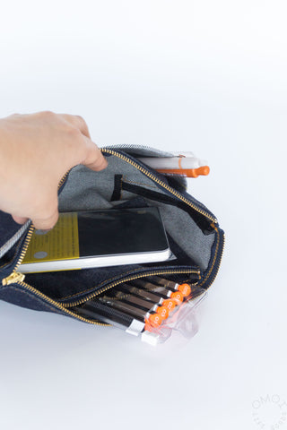 Open denim double-pocket pouch with zip-top, showing interior slots and tools