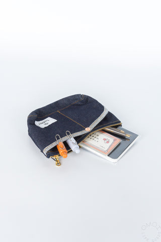 Denim double-pocket pouch with gold zipper, front tab, clips and card inside
