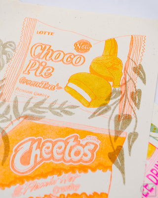 Close-up snack-themed print with "Choco Pie" and Cheetos in bright orange