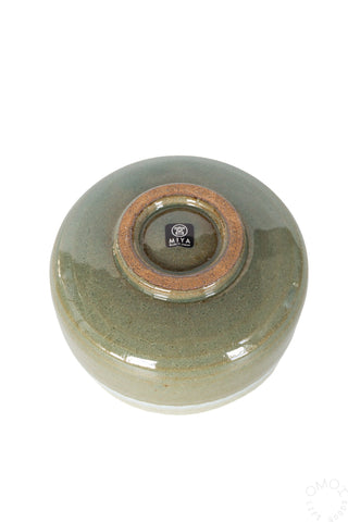 Bottom view of green glazed matcha tea bowl with circular stamp mark