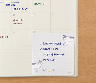 Cat-and-ball die-cut sticky notes on planner page, light grid with cat figures