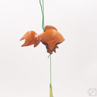 Orange fish wind chime hanging from green cords, showing layered fins and tail