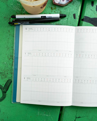 Blue A5 planner open to blank date grids for weekly planning