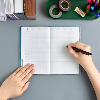Open weekly planner spread with date grids for writing appointments