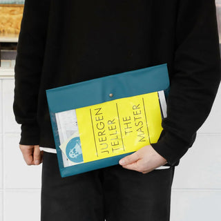 Blue general purpose case with snap button held by hands; clear pocket shows yellow card