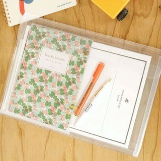 Clear general purpose case pouch holding a planner page, marker, and pencil; brass snap.