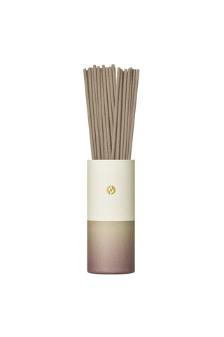 Tall cylindrical incense tube with bundled brown sticks, cream and mauve gradient