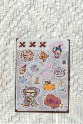 Opaque clear sticker sheet close-up with cute character icons and a small QR code