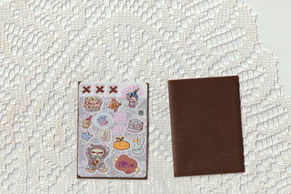 Opaque clear sticker sheet with cute icons, shown with a brown backing card