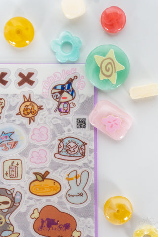 Transparent sticker sheet with colorful icons and cutout stickers on clear backing