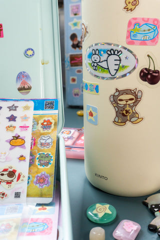 Sticker sheet on clear film with colorful cartoon characters and icons