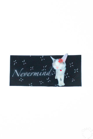 Vinyl sticker: black rectangle with white cat and “Nevermind” script, sparkle accents