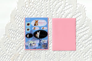 Sticker sheet with blue pet collage and matching pink sheet cover laid on white textured paper