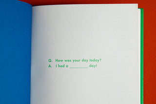 Open white notebook page with printed prompt and lined writing area, green binding