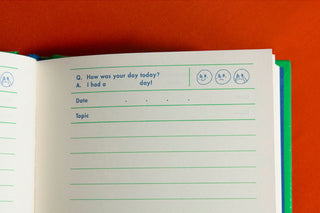 Open white notebook page with date and topic lines plus small icons, green edge