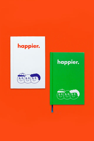White diary notebook cover with "happier." text and blue face illustration