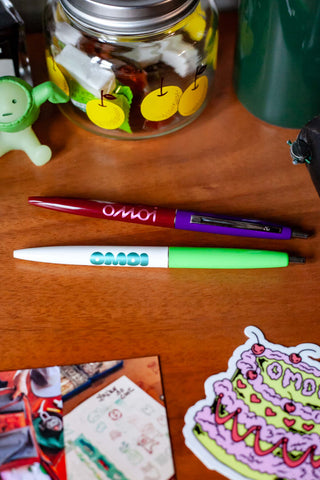 OMOI Shop Pen dark berry, capped ballpoint pen on wooden desk