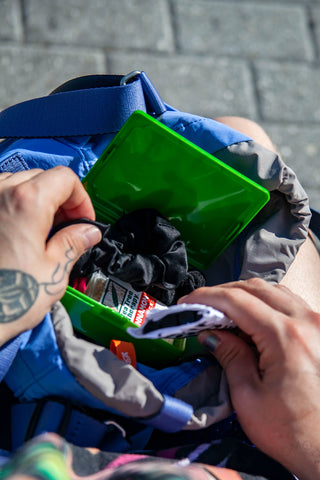 Open HIGHTIDE mini green tool box held in hands, showing small contents