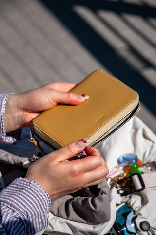 Tan leather folio wallet with zip closure and stitched edges