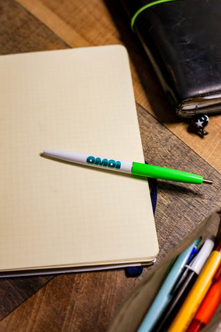 OMOI Shop Pen key lime green capped pen resting on a sketchbook