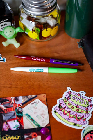 OMOI Shop Pen set: dark berry and key lime pens on wooden desk
