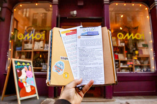 OMOI's short trips guidebook open in hand with itinerary text pages.