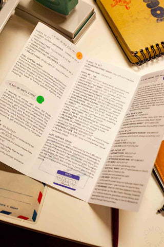 OMOI's short trips guidebook open on a desk with multiple text pages.