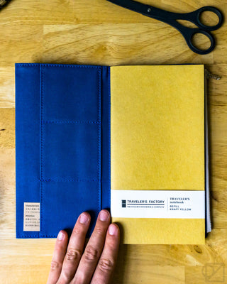 Blue and kraft yellow notebook refills in a hand-held two-pack