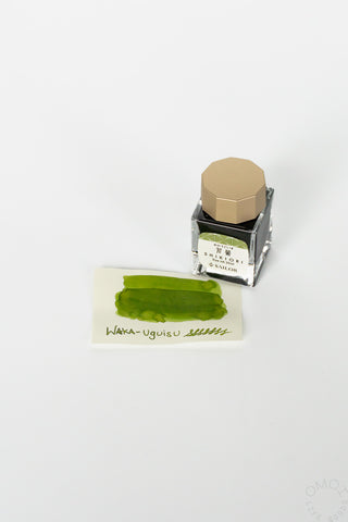 Wakauguisu bottled ink with dark green swatch card and clear bottle with gold cap