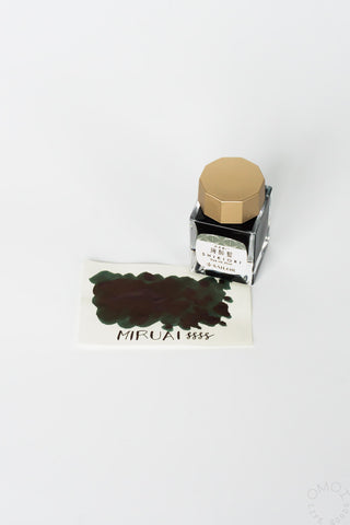 Miruai bottled ink with deep maroon swatch card and clear bottle with gold cap