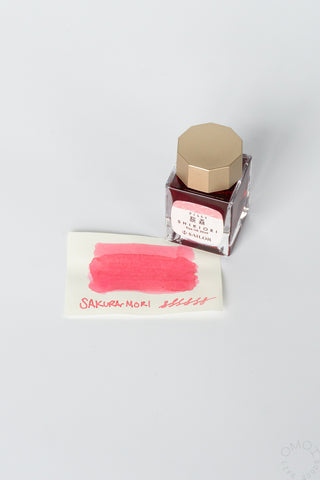 Sakuramori bottled ink with pink swatch card and clear bottle with gold cap
