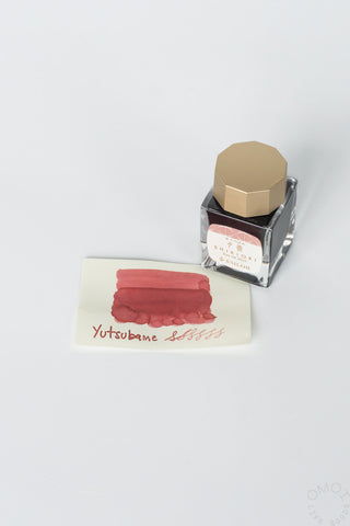 Yotsubame bottled ink with red swatch card and clear bottle with gold cap
