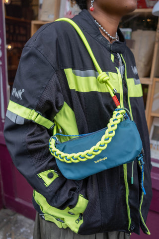 Neon lime braided O-rope strap with loop detail on a blue crossbody bag