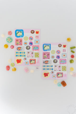 Sticker sheets with colorful icons scattered around on white background