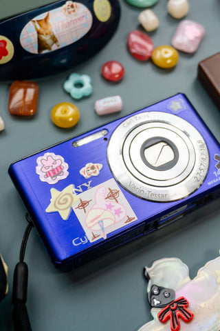 Blue device covered with colorful sticker icons, featuring a round “V” style emblem