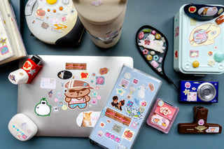 Sticker set on pink sheet featuring cartoon characters, hearts, and icons