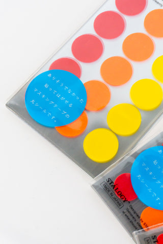 Circular washi tape dot stickers in red, orange, yellow, and blue on clear packs