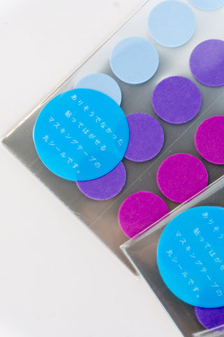 Clear tray of circular washi tape dot stickers in blue and purple tones