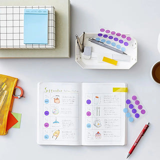 Open notebook with colorful circular sticker dots and labeled cards around it
