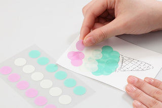 Pastel circular washi tape dot stickers in pink and mint on a paper sheet