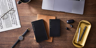 Black slim notebooks with yellow label band, stacked on a desk