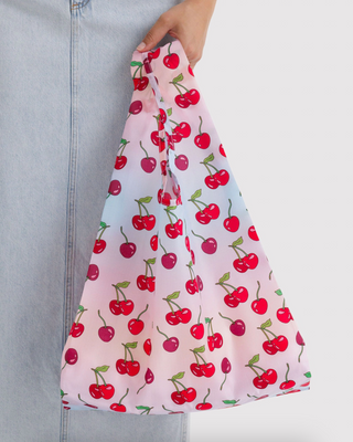 BAGGU standard tote bag held up, pink with red cherries and green stems