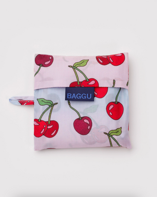 BAGGU standard tote bag folded, pink cherry print with blue BAGGU label