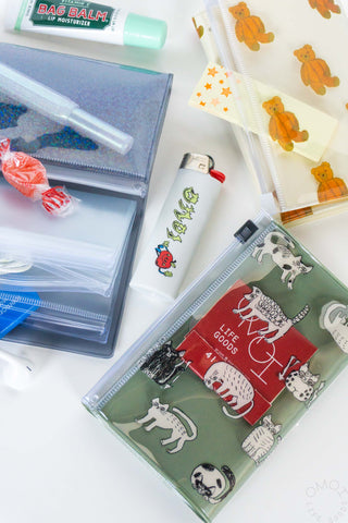 Small zip pouches with holographic and animal prints plus personal-care items