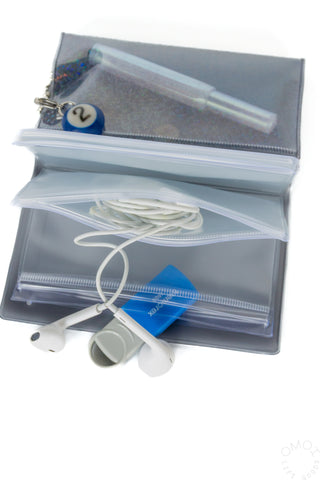 Holographic zip pouch opened with blue charm, cords, and small accessory items