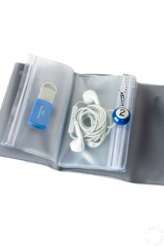 Black-and-gray pouch interior with transparent compartments, blue bottle, and earphones
